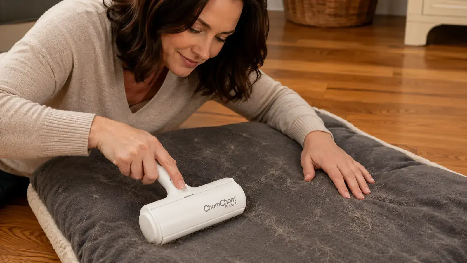 Hand rolling the ChomChom back and forth across a dark fleece blanket covered in white dog hair